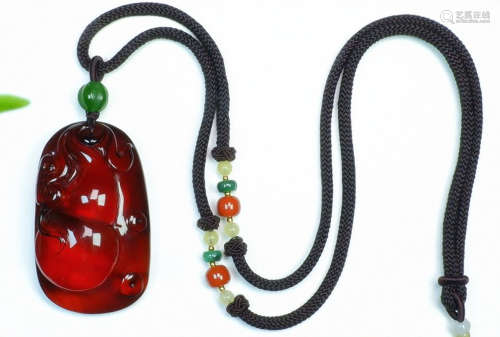 AN AMBER CARVED AUSPICIOUS PATTERN PENDANT