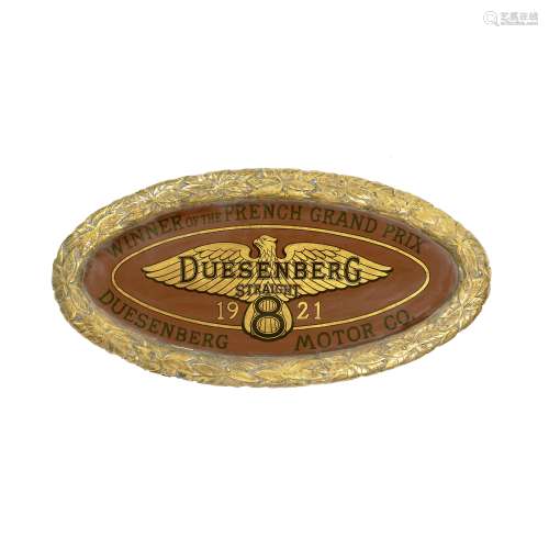 An oval plaque celebrating Duesenberg's 1921 French Grand Prix victory,