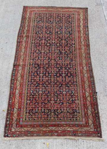 Property of a lady - a Persian Serebend long rug, with navy field, 141 by 69ins. (358 by 175cms.).