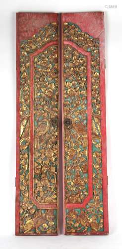 Property of a gentleman - a pair of Indian carved gilt & red painted doors, each 72.75ins. (185cms.)