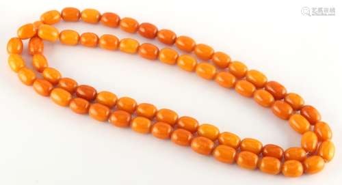 Property of a lady - a butterscotch amber bead necklace, the uniform oval beads each approximately
