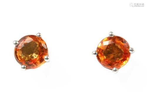 A pair of white gold orange sapphire stud earrings,