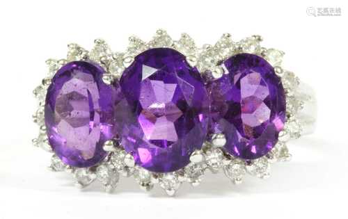 A 9ct white gold amethyst and diamond triple cluster ring,