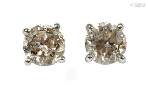 A pair of platinum single stone diamond stud earrings,