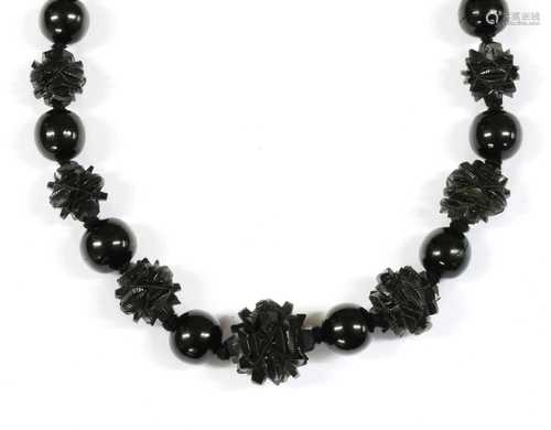 A single row graduated carved jet bead necklace,