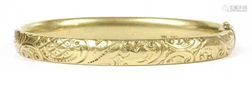 A gold hollow hinged oval bangle,