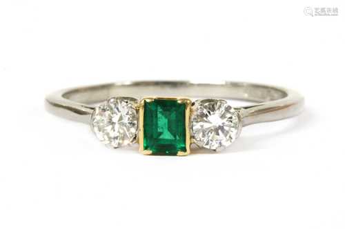 A platinum and gold, emerald and diamond three stone ring,