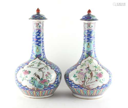 A pair of Chinese blue ground famille rose bottle vases & covers, late 19th / early 20th century,