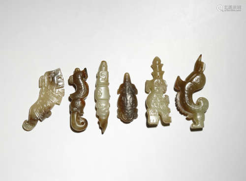 SIX SMALL CHINESE ARCHAISTIC CELADON AND RUSSET JADE PENDANTS PROBABLY QING DYNASTY Formed as
