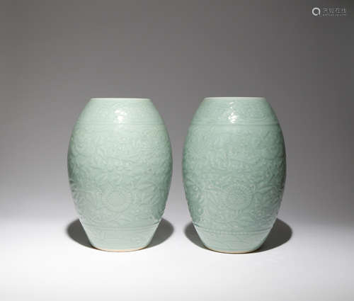 A PAIR OF CHINESE CELADON GLAZED BARREL-SHAPED VASES LATE QING DYNASTY Each carved to the exterior