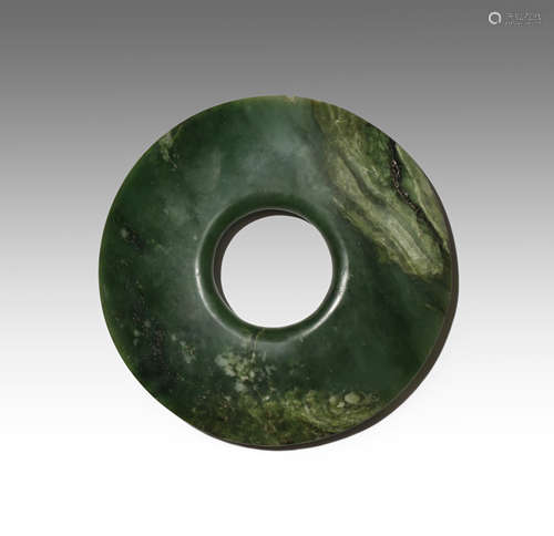 A CHINESE ARCHAISTIC SPINACH-GREEN JADE BI PROBABLY LATE QING DYNASTY The disc tapering at the