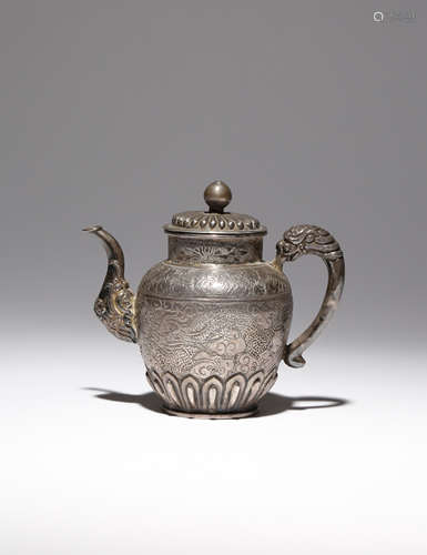 A TIBETAN REPOUSSE AND INCISED SILVER EWER AND COVER 19TH CENTURY Set with a makara-shaped spout and