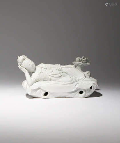 A CHINESE BLANC DE CHINE FIGURE OF GUANYIN 18TH CENTURY Depicted reclining on a large plantain