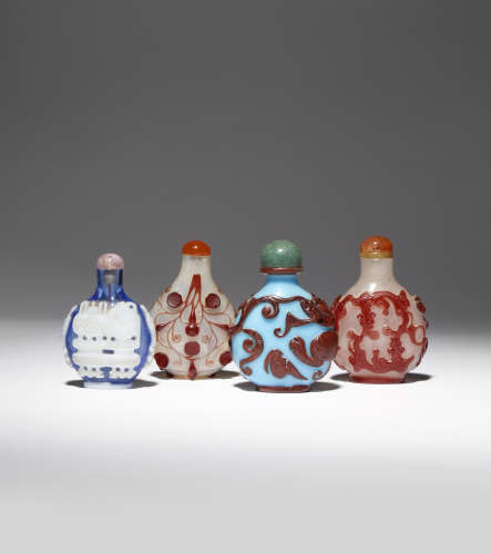 FOUR CHINESE OVERLAY GLASS SNUFF BOTTLES 19TH CENTURY The smallest carved with archaistic vessels in