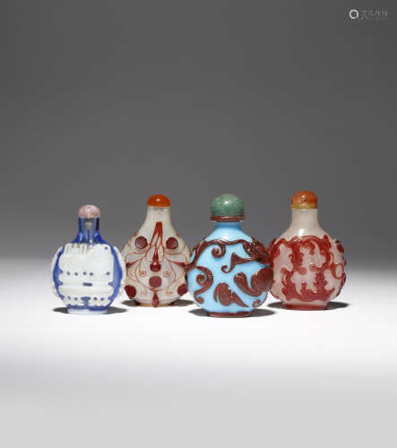 FOUR CHINESE OVERLAY GLASS SNUFF BOTTLES 19TH CENTURY The smallest carved with archaistic vessels in