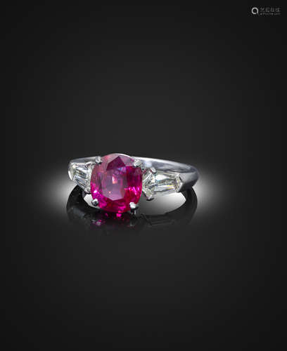 A ruby and diamond three-stone ring, the cushion-shaped ruby weighs 3.57cts, set with fancy-cut