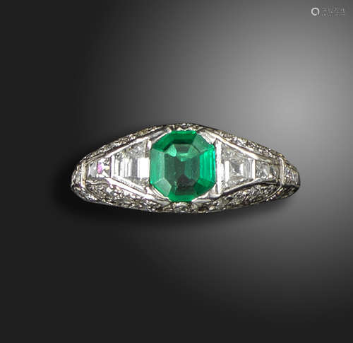 An Art Deco emerald and diamond ring by Tiffany & Co, the emerald-cut emerald is flanked by