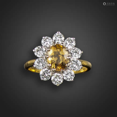 A topaz and diamond cluster ring, the oval-shaped orange topaz set within a surround of round