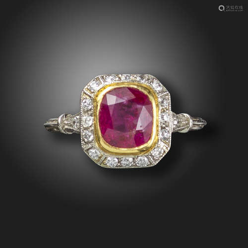 A ruby and diamond cluster ring, set with a cushion-shaped ruby within a surround of old circular-