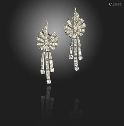 A pair of diamond drop earrings, the stylised bow sections suspend three asymmetrical articulated