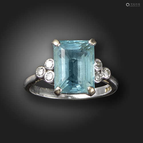 An aquamarine and diamond ring, the rectangular aquamarine is flanked with diamond trefoils in