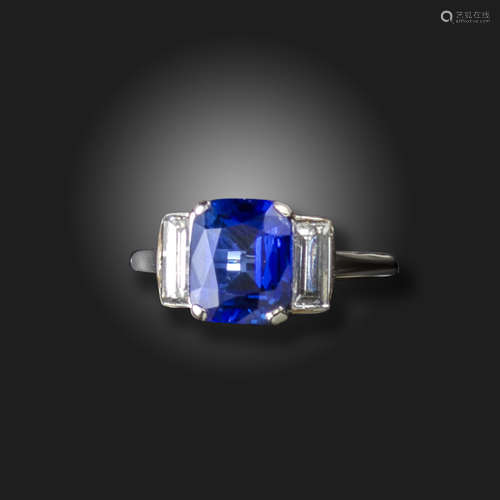 A sapphire and diamond three stone ring, the cushion-shaped sapphire is flanked with baguette-shaped