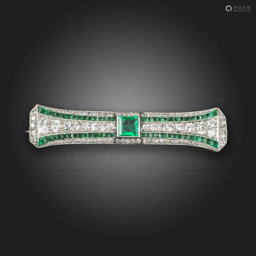 An Art Deco emerald and diamond brooch, centred with a square-shaped emerald, within a surround of