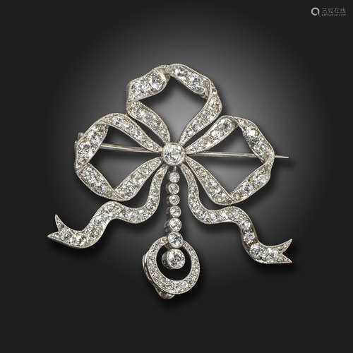 An Edwardian diamond-set bow brooch, the sylised bow millegrain-set with graduated old cushion-