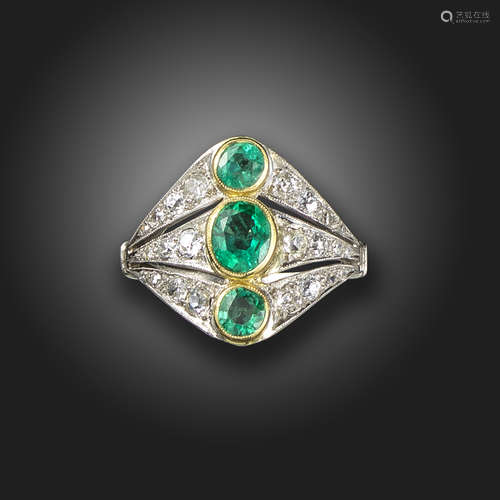 An emerald and diamond ring, set with three graduated oval-shaped emeralds, with graduated old