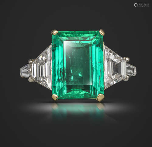 An emerald and diamond ring, the emerald-cut emerald weighs 5.03cts, set with a trapeze-shaped and