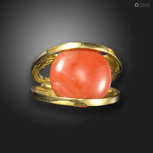 л A coral-set gold ring, of openwork design, the button-shaped coral cabochon set between two gold