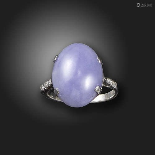 A lavender jade and diamond ring, the jadeite cabochon is set with diamond shoulders in white