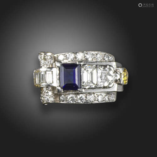 An Odeonesque sapphire and diamond ring, set with an emerald-cut sapphire within scrolling border of