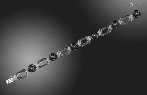 A diamond-set onyx and rock crystal bracelet, the carved openwork rock crystal links alternately-set