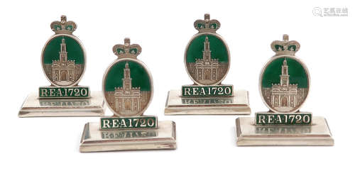 A set of four silver and enamel menu card holders, Birmingham 1919, modelled as the badge of the