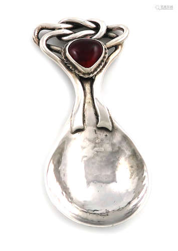 By Omar Ramsden, an Arts and Crafts silver caddy spoon, London 1919, spot-hammered fig-shaped