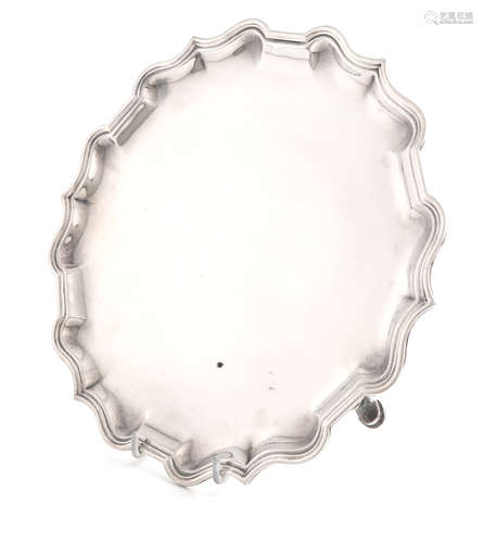 A silver salver, by Charles Stuart Harris, London 1925, circular form, moulded border, on three hoof