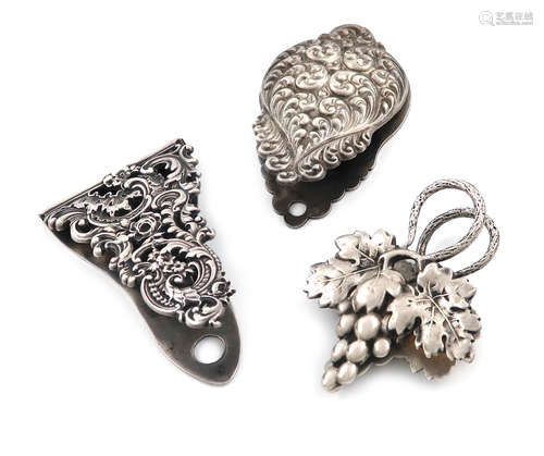 Two silver paper clips, stamped STERLING, one with pierced foliate scroll decoration and one with