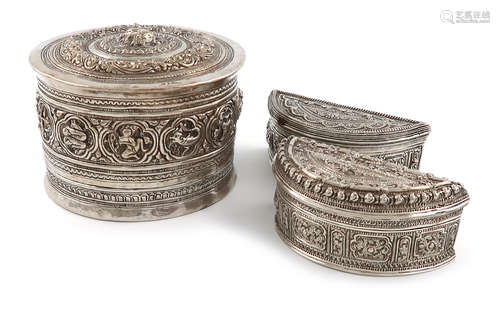 Three Burmese silver betel nut boxes, comprising: one of circular form, chased with signs of the