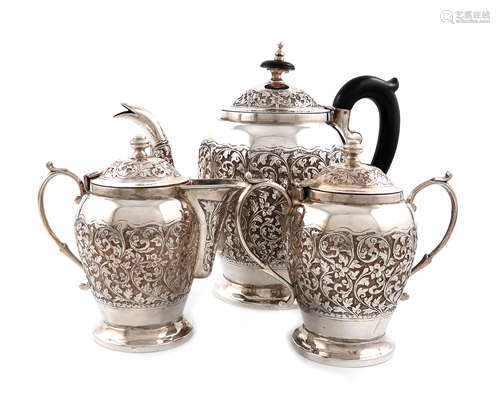 A three-piece Indian metalware tea set, unmarked hinged covers, baluster form, chased foliate scroll