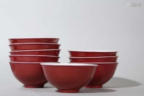 A SET OF NINE SMALL CHINESE COPPER RED-GLAZED BOWLS.