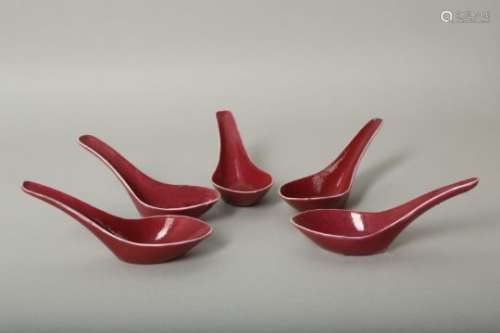 A SET OF FIVE CHINESE COPPER RED GLAZED SPOONS.