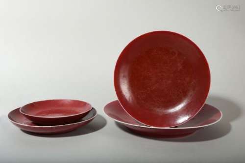 A SET OF FOUR COPPER RED-GLAZED DISHES.