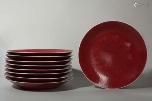 A SET OF NINE LARGE CHINESE COPPER RED GLAZED DISHES.