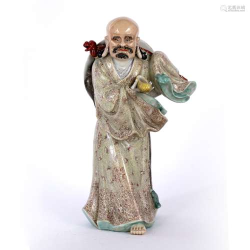 Porcelain model of Lohan Chinese dressed in flowing robes with one hand holding a shoe, with his hat