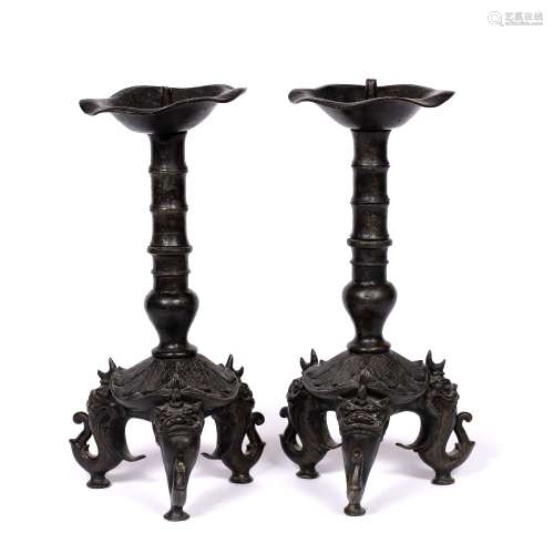 Pair of bronze candlesticks Chinese, Ming Dynasty (1368-1644) each raised on three legs, cast as