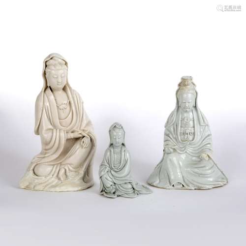Three dehua figures of Guanyin Chinese, 19th Century two modelled holding a scroll to one hand, with