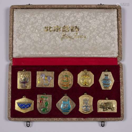 Ten boxed plaques Chinese gilt metal with enamelling depicting exhibition vessels, produced as a