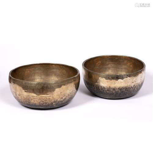 Two singing bowls Nepalese with incised decoration to the bodies, the middle having two lines