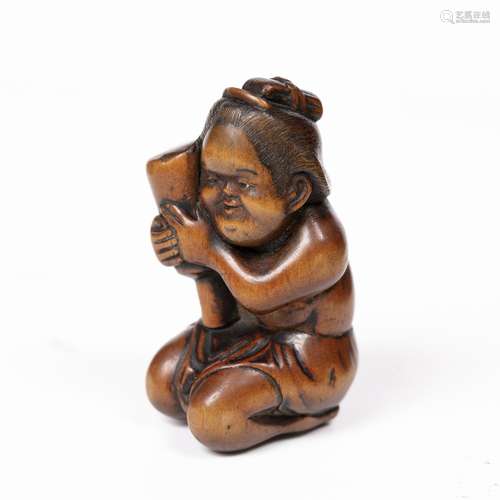 Wood netsuke of Okame Japanese, Osaka School, Edo period in a shunga suggestive pose depicting her